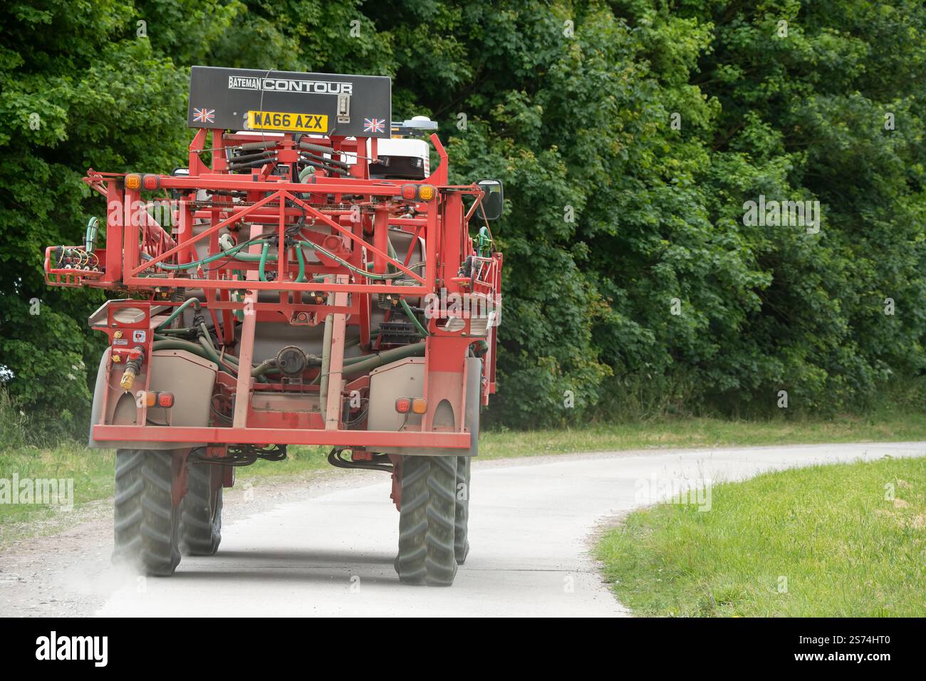 Eine große Feldspritze für Rotwein in Aktion auf einem Feld mit Jungweizen Stockfoto