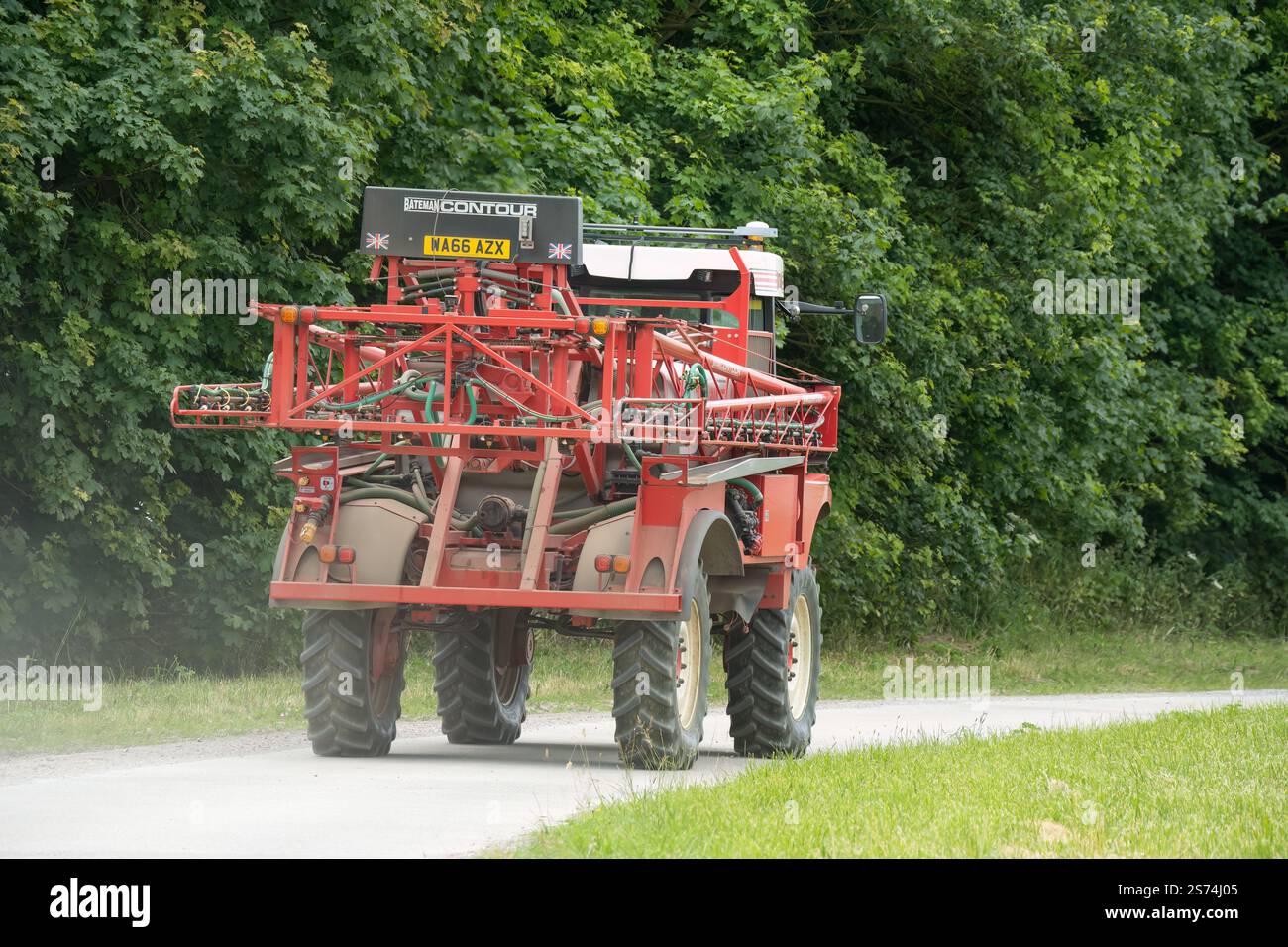 Eine große Feldspritze für Rotwein in Aktion auf einem Feld mit Jungweizen Stockfoto