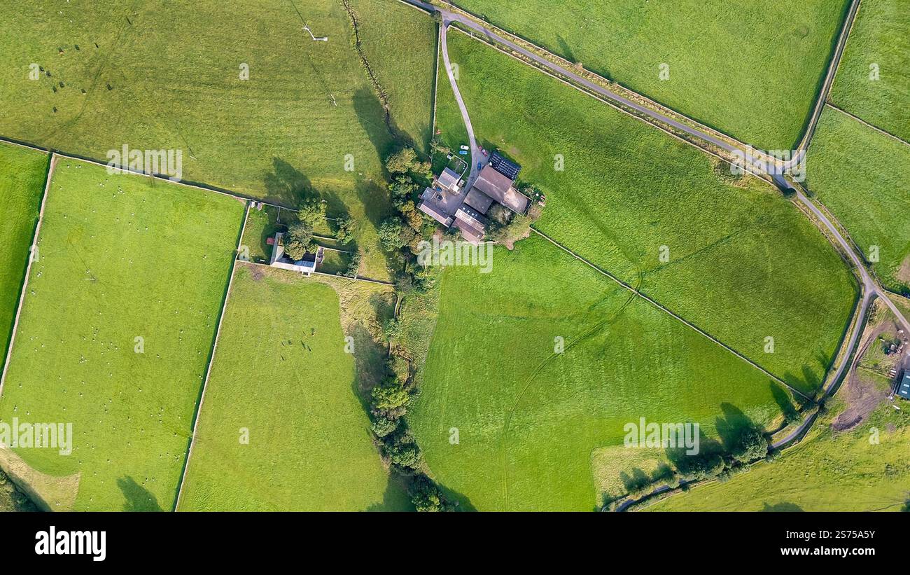 Von oben nach unten aus der Drohne Blick auf den britischen Bauernhof mit Steinhäusern umgeben von grünen Feldern northumberland uk Erbschaftssteuer Stockfoto
