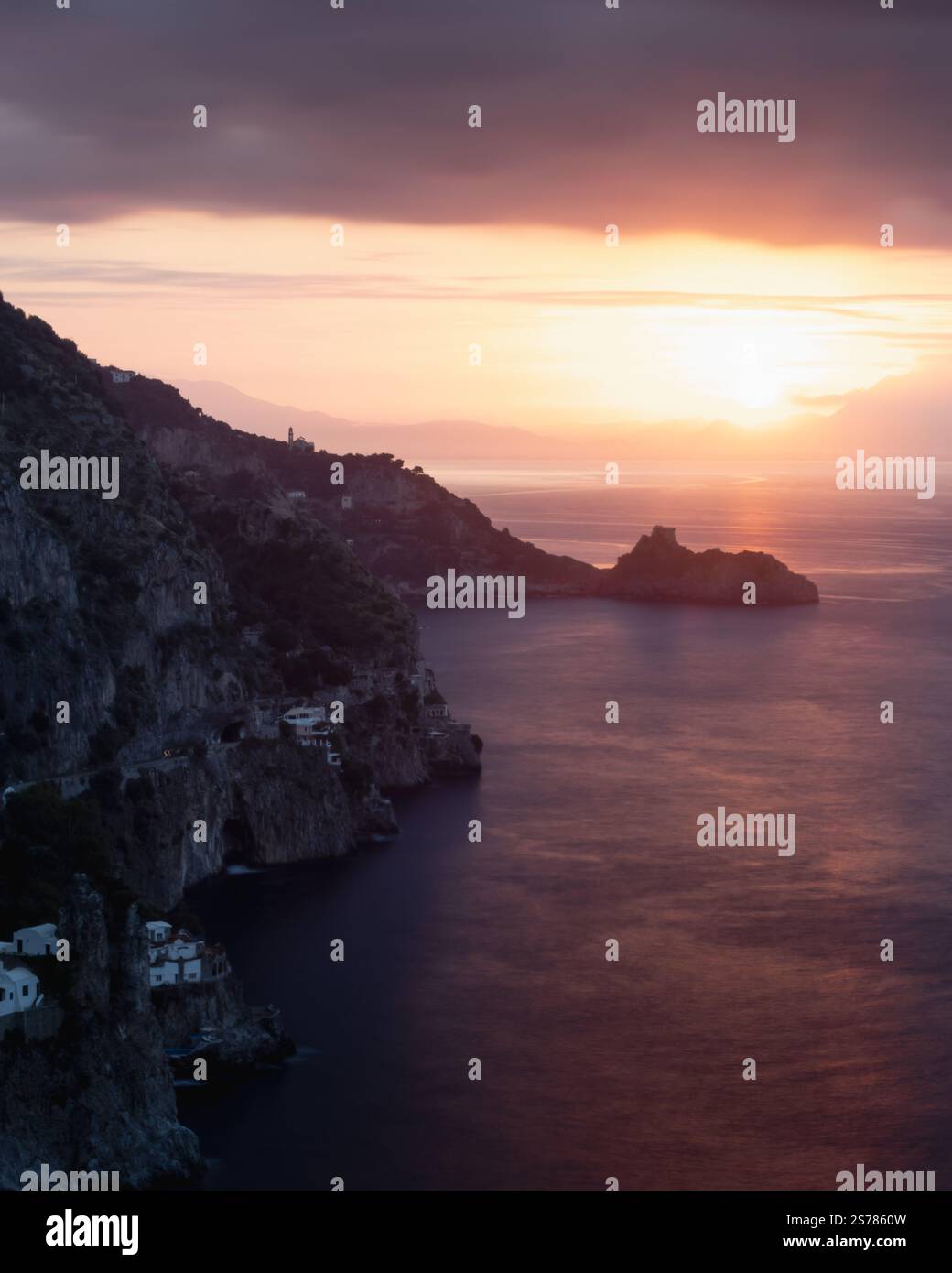 Ein dramatischer Sonnenaufgang über der Amalfiküste in Italien, mit strahlendem Licht über der Meereslandschaft. Eine atemberaubende Landschaft voller lebendiger Farbtöne. Stockfoto