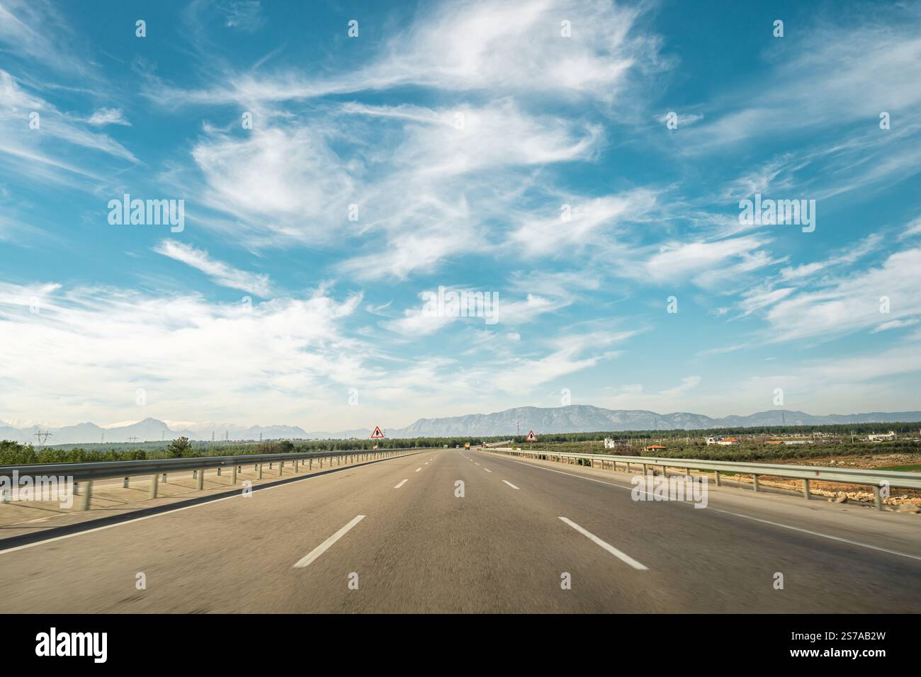 Dreispuriger Highway, der an einem sonnigen Tag vorwärts fährt Stockfoto