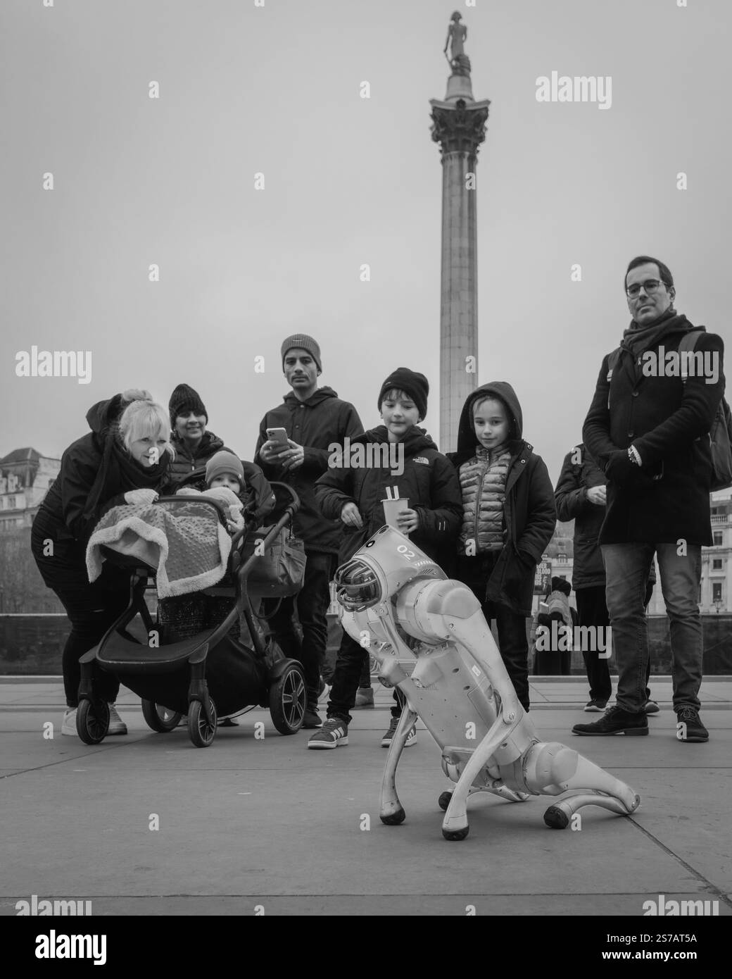 Kuriose Touristen beobachten, wie ein Black Panther 2,0 vierbeiniger Roboterhund in der Nähe des Trafalgar Square auftritt. Stockfoto