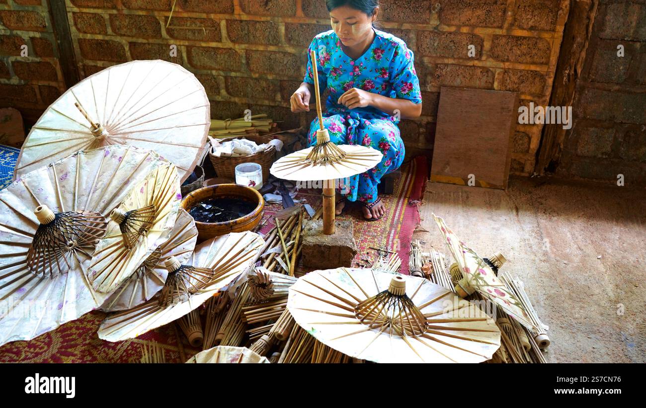Myanmar - 19. Januar 2025 - Foto der Frau, die Regenschirme in der traditionellen Werkstatt herstellt Stockfoto