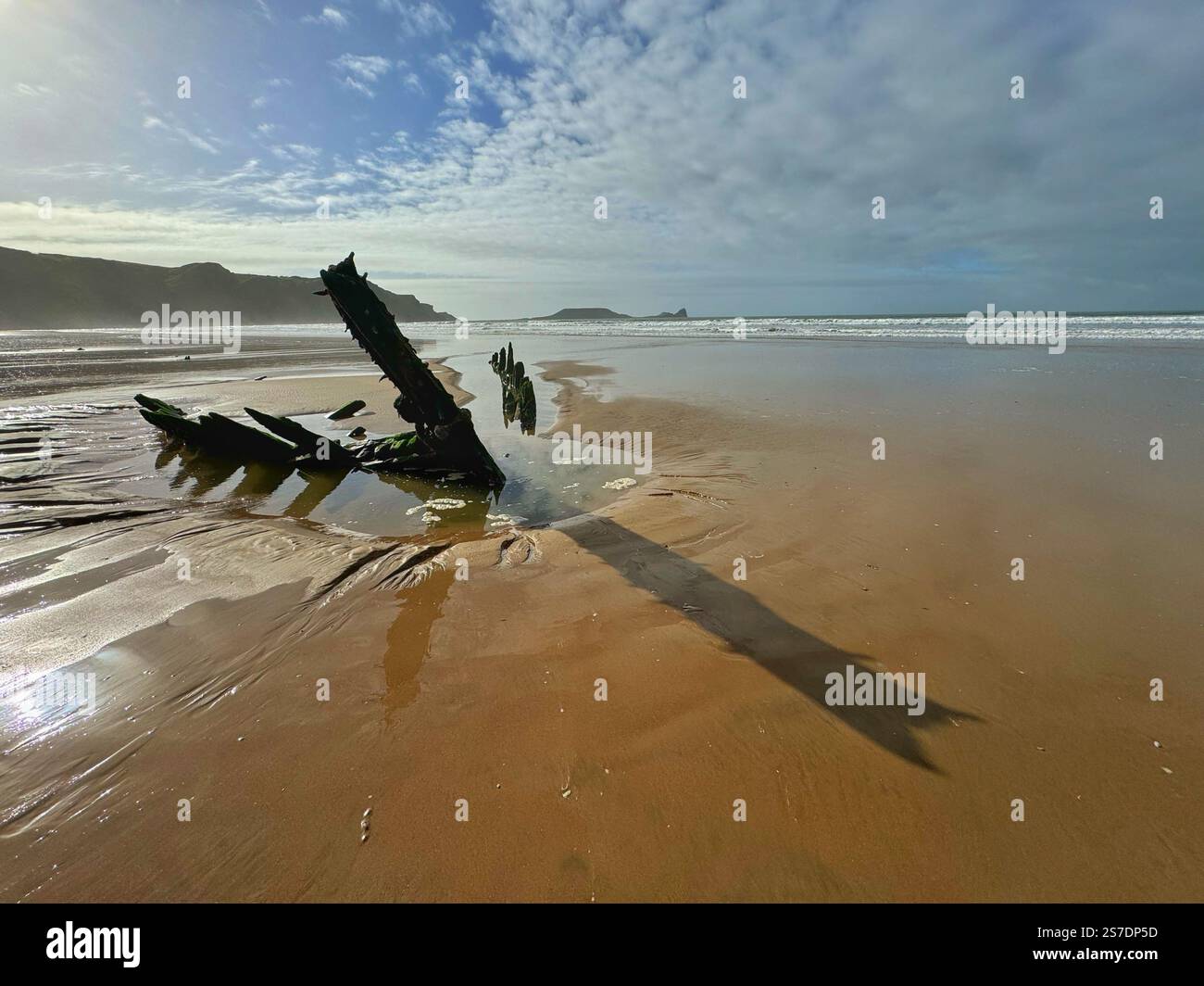 Rhossili Strand mit dem Wrack der Helvetia und Worm's Head in der Ferne, Gower, Swansea, Wales. Stockfoto