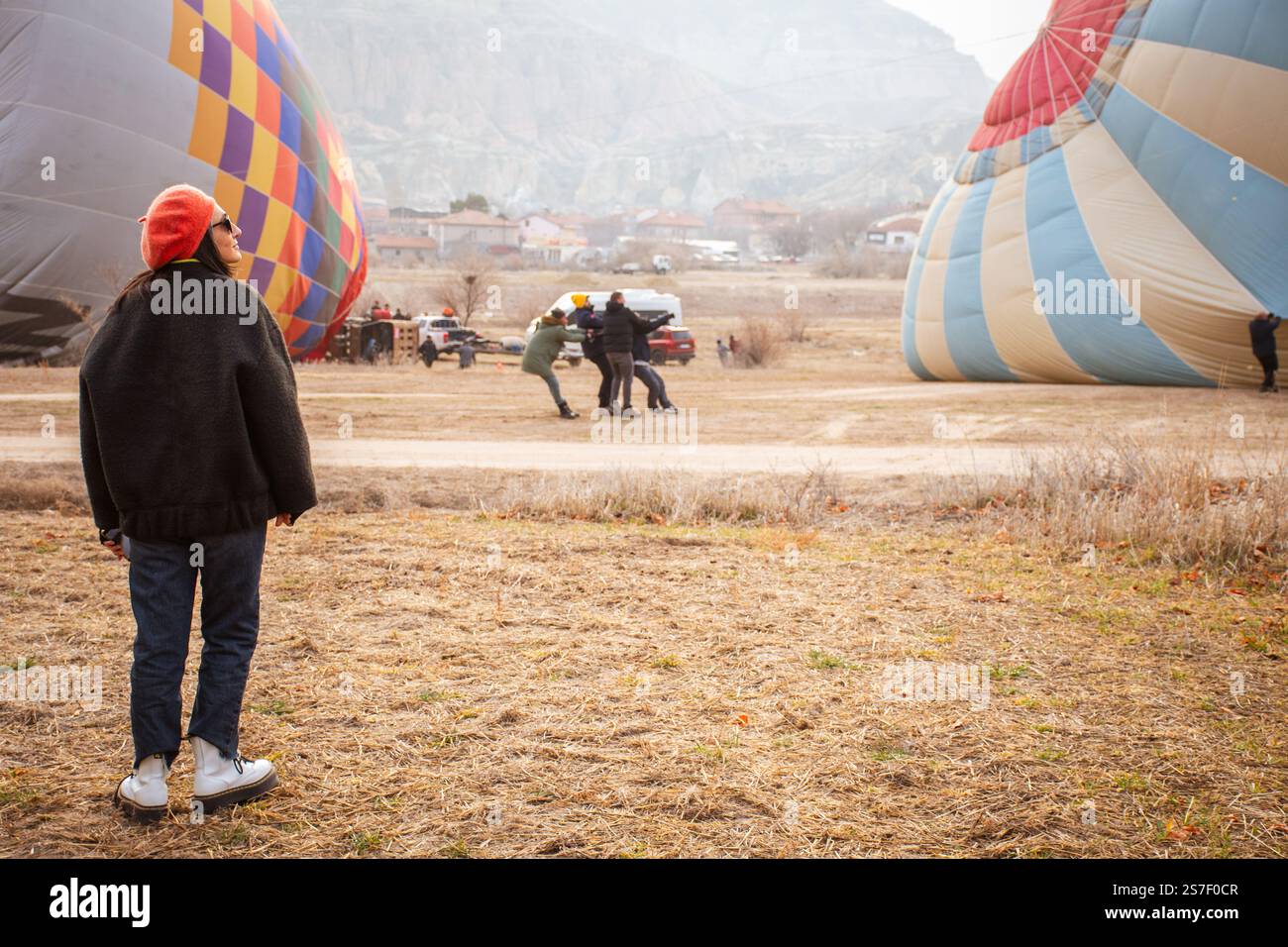 Goreme, Türkei - 27. dezember 2024: Touristen Kunden beobachten Heißluftballon Fluggesellschaft Arbeiter arbeiten hart ziehen Heißluftballon vor dem Flug in Capp Stockfoto