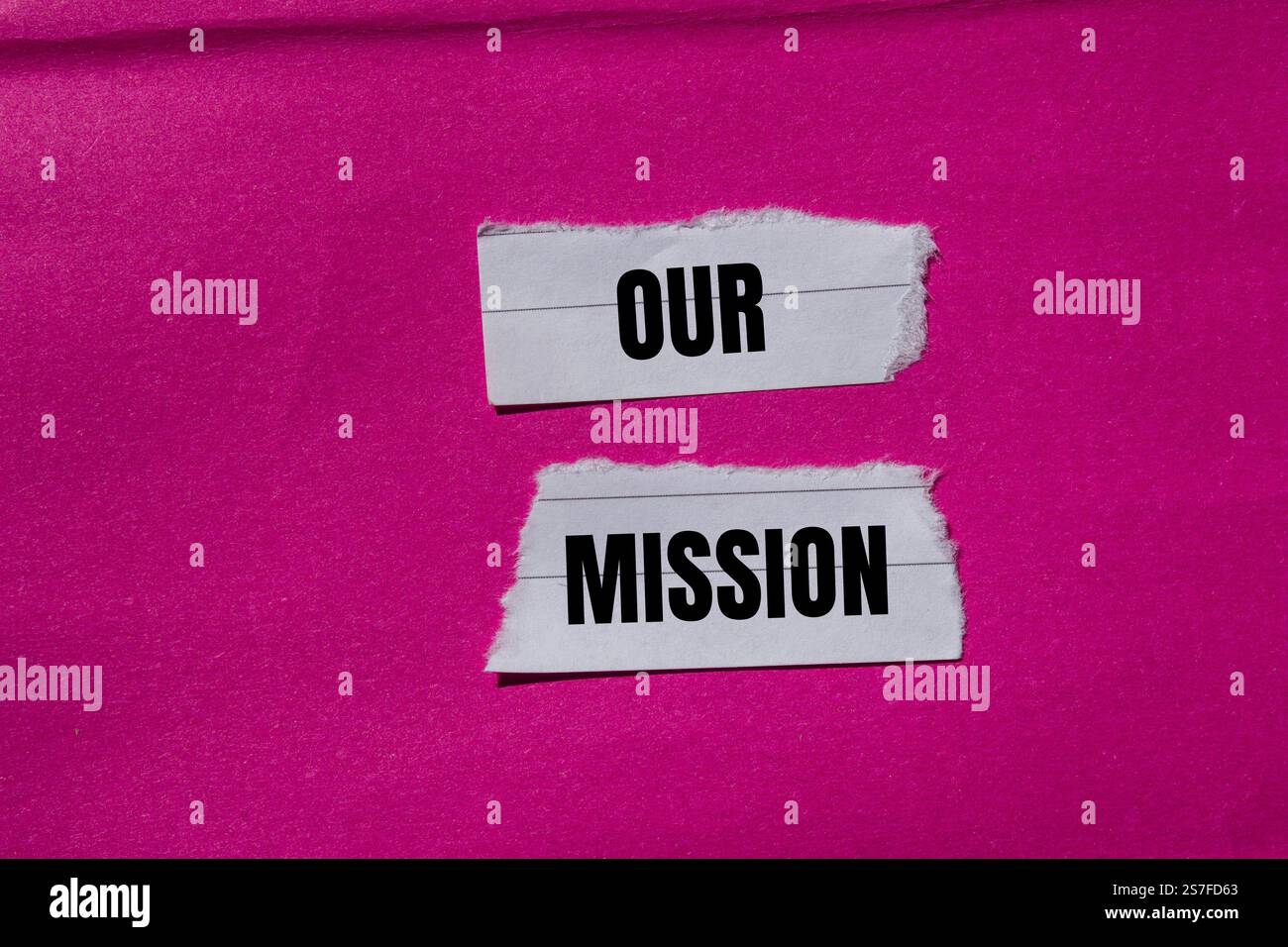 Unsere Botschaft steht auf zerrissenen Papierstücken mit rosa Hintergrund. Konzeptionelles unser Missionssymbol. Kopierbereich. Stockfoto