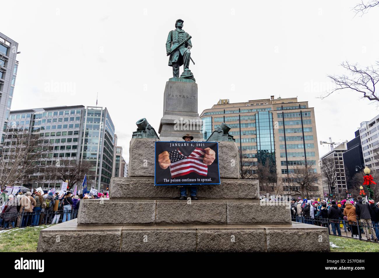 Washington, Dc, Usa. Januar 2025. Der Protestor steht auf dem Admiral Farragut Monument auf dem Farragut Square, als er sich bereit macht, am Volksmarsch gegen den designierten Präsidenten Donald Trump in Washington, DC teilzunehmen. Quelle: SOPA Images Limited/Alamy Live News Stockfoto