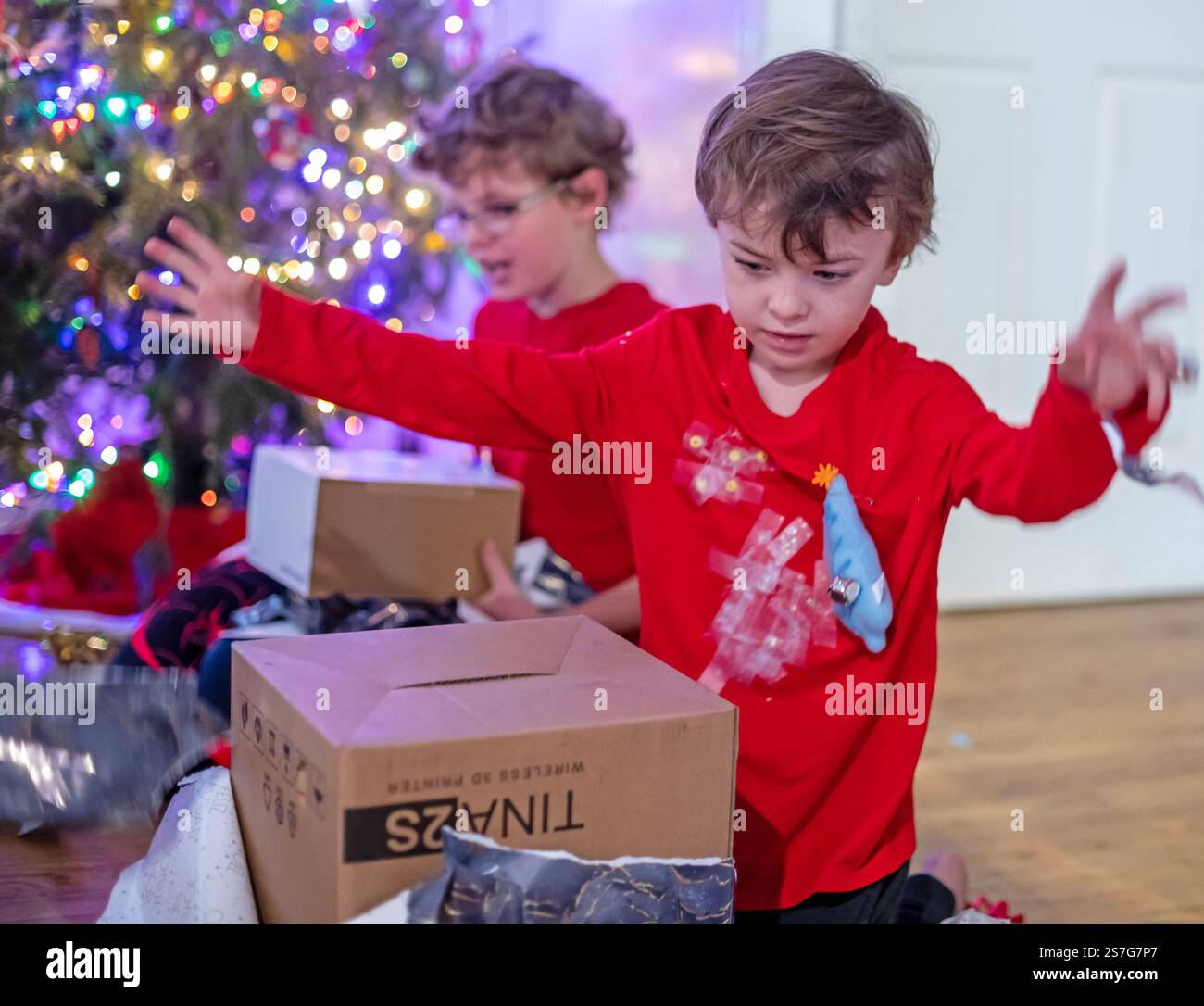 Denver, Colorado – Hendrix Hjermstad, 6, (rechts) und sein Bruder Adam Hjermstad Jr., 10, öffnen Weihnachtsgeschenke am Weihnachtsmorgen. Stockfoto