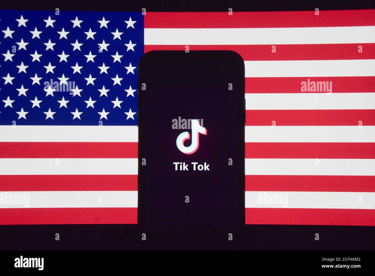 London, Großbritannien. Januar 2025. TikTok-Logo auf einem Telefonbildschirm und die Flagge der USA. In den USA wurde der Dienst nun wiederhergestellt, nachdem das Urteil des Obersten Gerichtshofs ein Verbot der chinesischen Social-Media-App bestätigt hat. Quelle: Vuk Valcic/Alamy Stockfoto