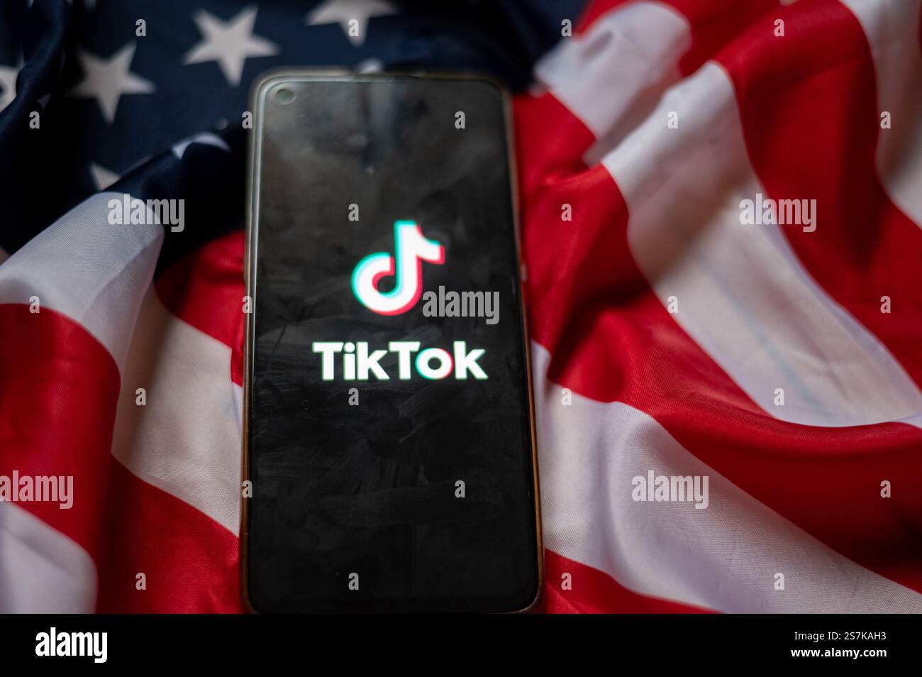 TikTok auf dem Bildschirm des Smartphones mit Hintergrund der USA-Flagge Stockfoto