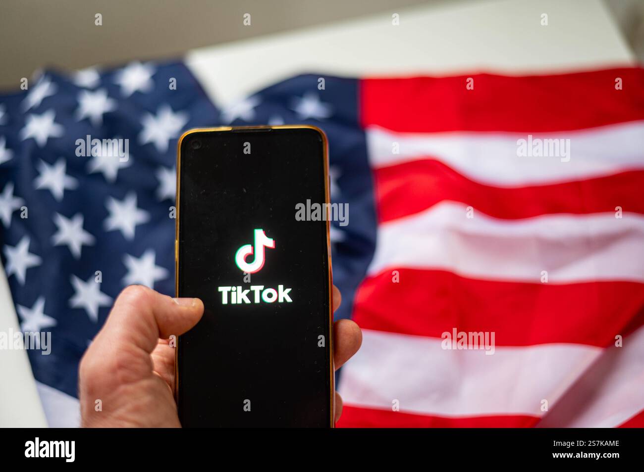 TikTok auf dem Bildschirm des Smartphones mit Hintergrund der USA-Flagge Stockfoto