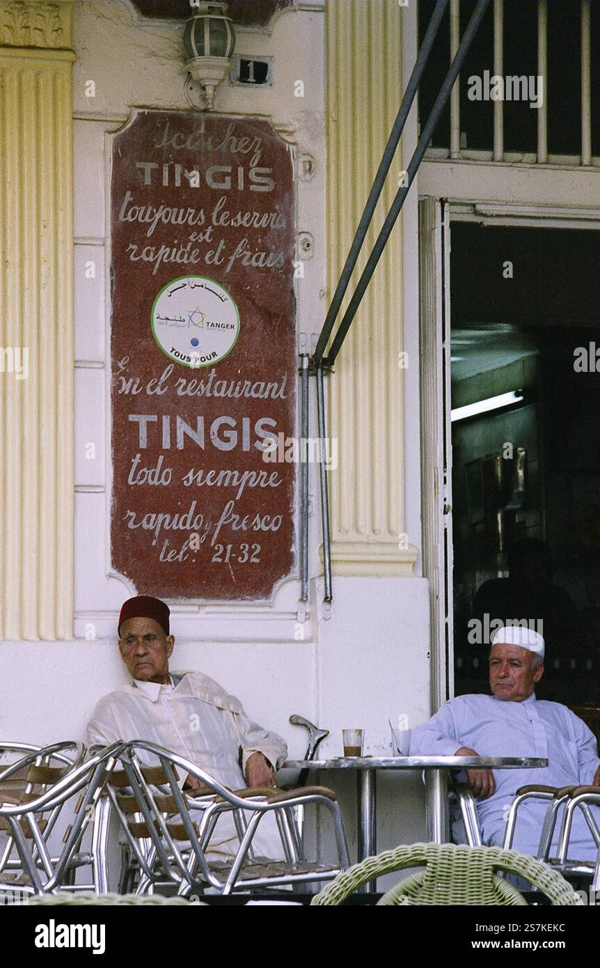 Zwei ältere marokkanische Herren in religiöser Kleidung sitzen an einem Tisch in einem Café und trinken Tee in Tanger, Marokko. Stockfoto