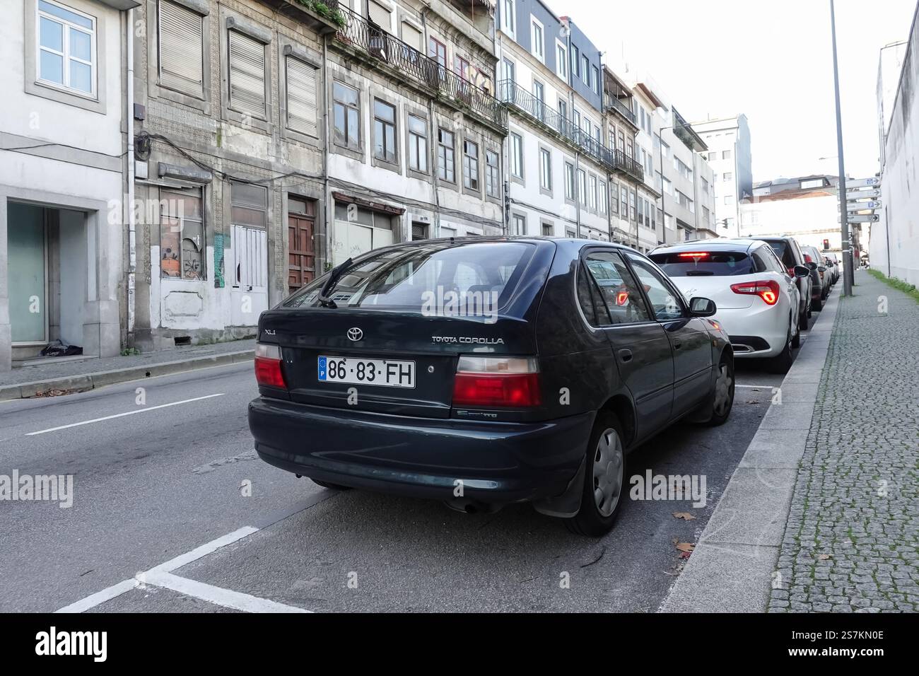 Eine Straße in Porto mit geparkten Autos auf einer Seite Stockfoto