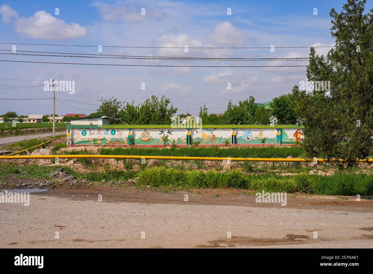 Junge Schule außerhalb von Termez, der Hauptstadt der Region Surxondaryo im Süden Usbekistans, Zentralasien - Wandmalerei mit einer Zeichentrickfigur Stockfoto