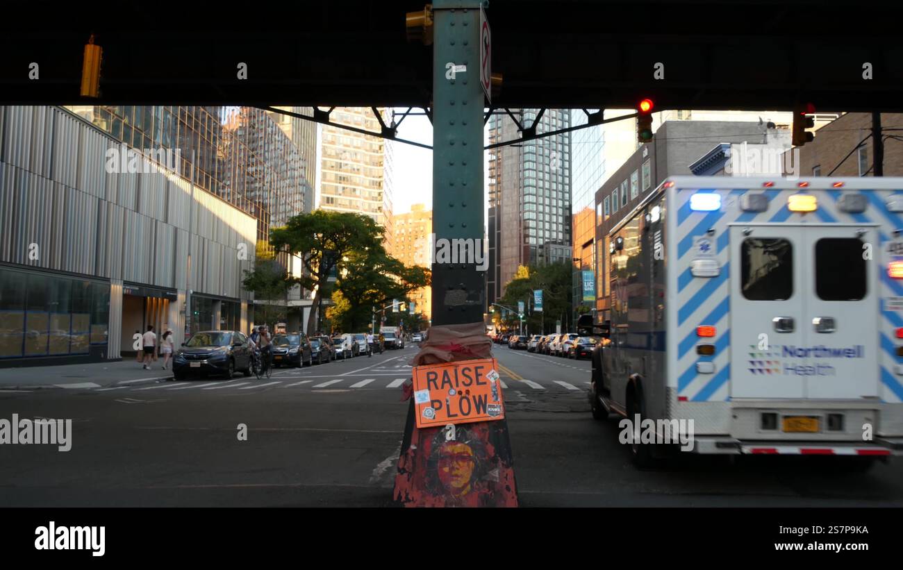 New York City, Vereinigte Staaten - 1 Sept 2023: Krankenwagen medizinischer Notfall, amerikanischer Sanitäter-LKW. Fahrzeug USA 911. NYC Ersthelfer Auto. Queens erhöhte U-Bahn, Long Island Street, Leute. Stockfoto