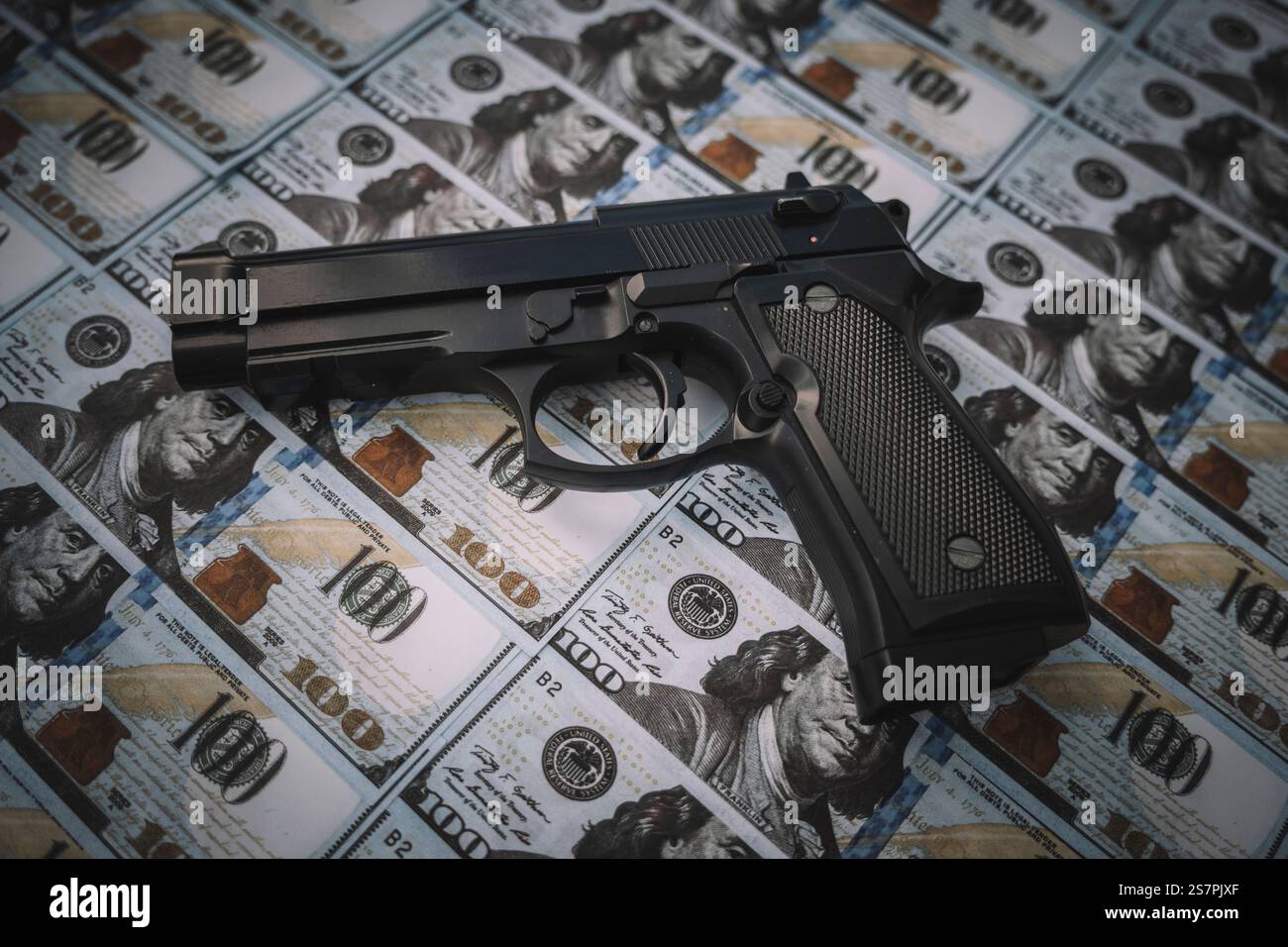 Schwarze Waffe im Hintergrund von Bargeld. Der Begriff kriminelles Geld oder Söldneraktivitäten. Kriminelle Geschäfte Stockfoto