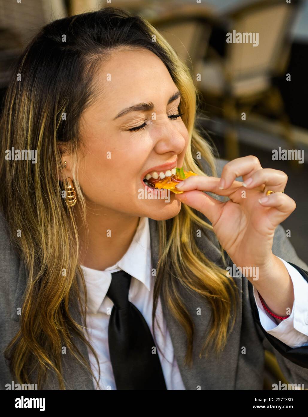 Eine junge Frau isst Nachos mit Käse in einem Restaurant Stockfoto