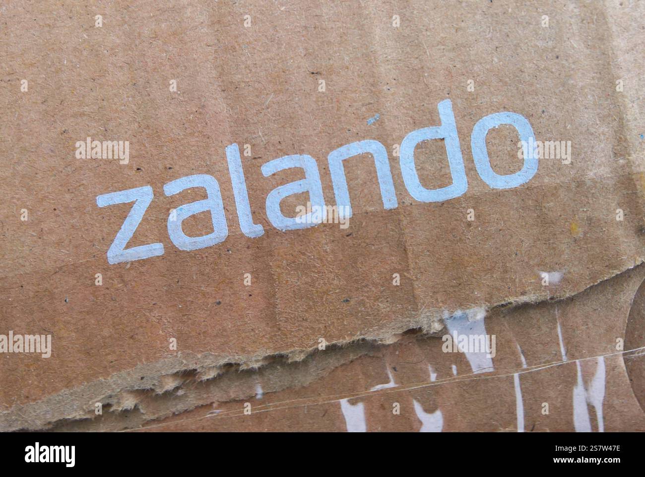 Die Zalando SE mit Sitz in Berlin ist ein börsennotierter deutscher Online-Versandhändler für Schuhe, Kleidung, Kosmetik und Accessoires. Das Unternehmen wurde 2008 von David Schneider und Robert Gentz gegründet und hat mehr als 50 Millionen aktive Kunden in 25 europäischen Märkten. Zalando ist in mehreren Geschäftsfeldern tätig, vom Internet-Shop über Eigenmarken, stationären Outlets in zwölf deutschen Städten. Foto: Zalando-Schriftzug auf einem Paket *** die Zalando SE mit Sitz in Berlin ist ein börsennotiertes deutsches Online-Versandunternehmen für Schuhe, Bekleidung, Kosmetik und Accessoires Stockfoto