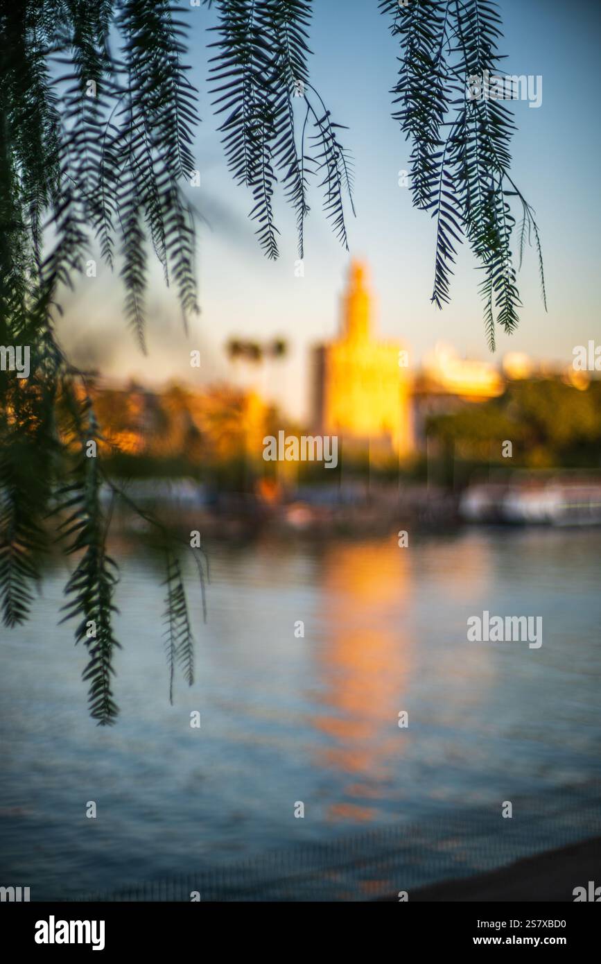 Eine traumhafte Darstellung des Torre del Oro und des Guadalquivir-Flusses unter goldenem Licht. Stockfoto