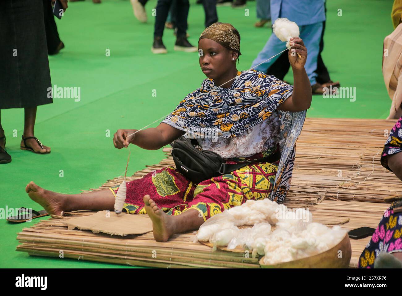 Abidjan, Elfenbeinküste. Januar 2025. Eine Frau zeigt den Prozess der Baumwollproduktion während der ersten Ausgabe des National Cotton and Cashew Producers' Day von Cote d’Ivoire, Abidjan, Cote d’Ivoire, 17. Januar 2025. Ziel der Veranstaltung war es, die Leistungen der nationalen Baumwolle- und Cashewerzeuger anzuerkennen und den Wert dieser beiden wichtigen Agrarsektoren für die Wirtschaft der Elfenbeinküste zu erhöhen. Quelle: Laurent Idibouo/Xinhua/Alamy Live News Stockfoto