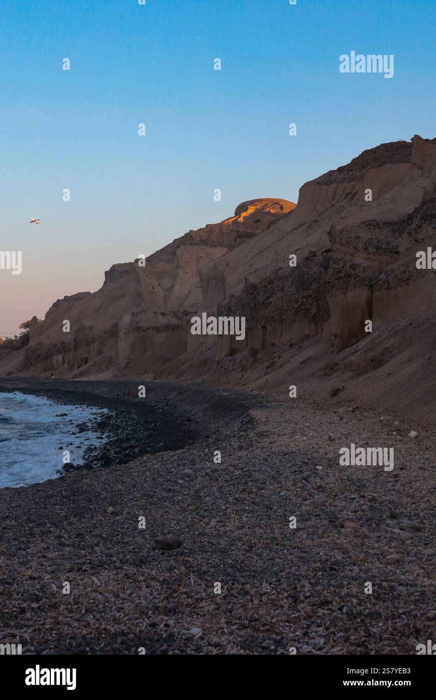 Santorins vulkanische Küste während der goldenen Stunde. Stockfoto