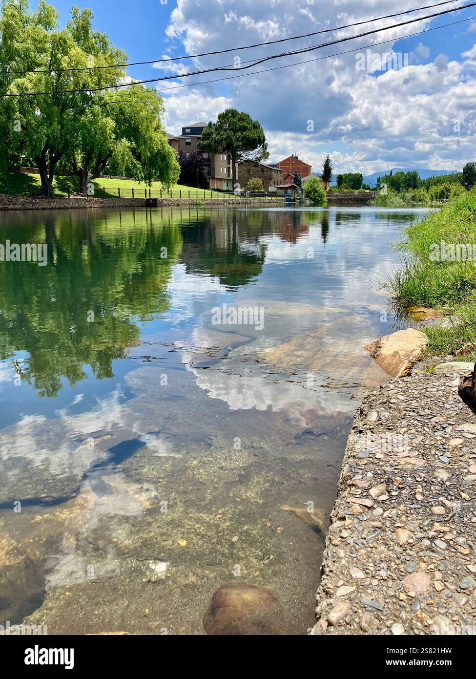 Ruhige Flussszene mit Reflektionen der Wolke und dem hellen blauen Himmel. - Smartphone-aufgenommenes Stockfoto