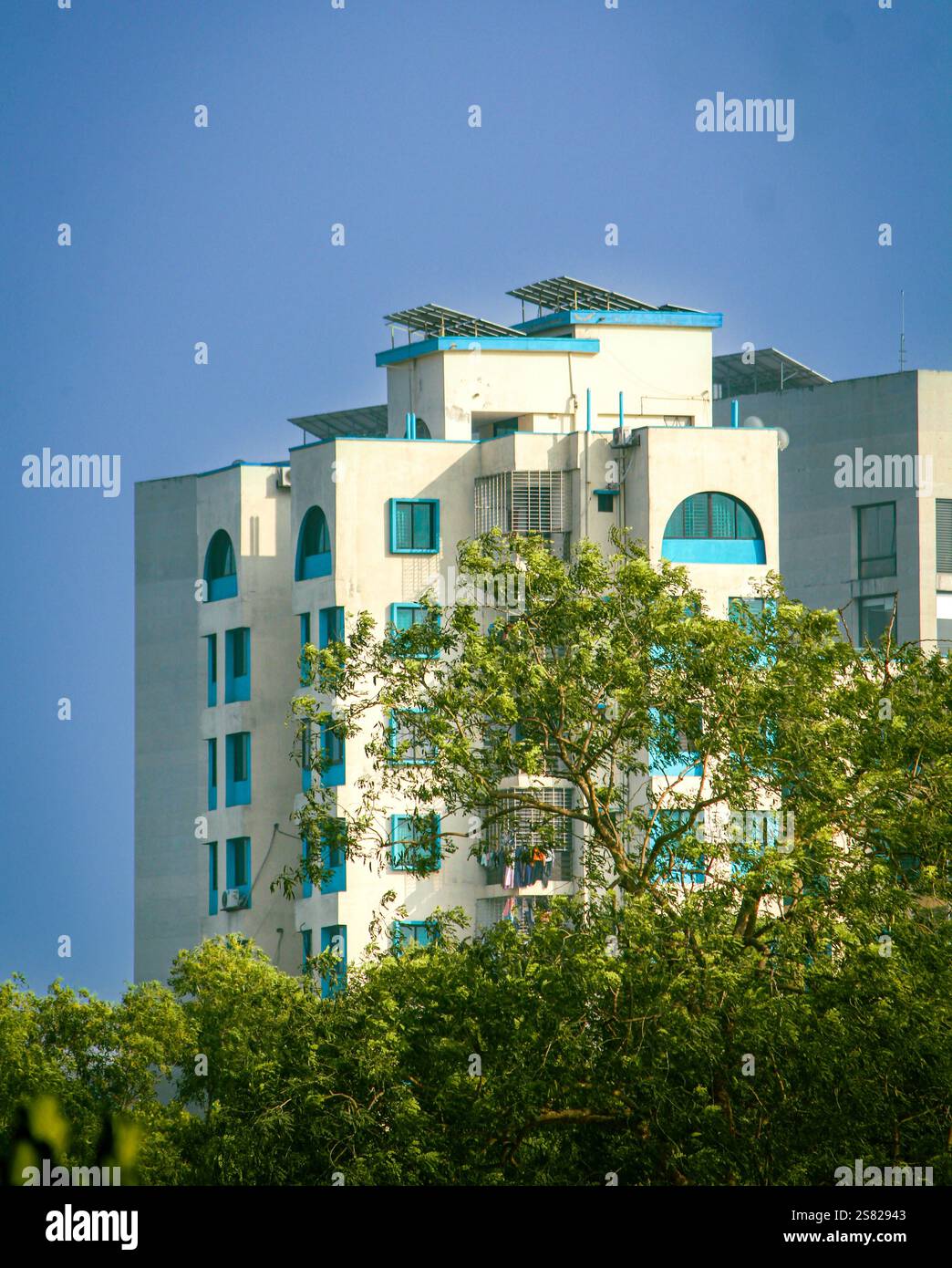 Ein majestätisches Gebäude in der Skyline von Dhaka unter einem atemberaubenden Himmel, das die perfekte Mischung aus moderner Architektur und lebendiger urbaner Atmosphäre bietet. Stockfoto