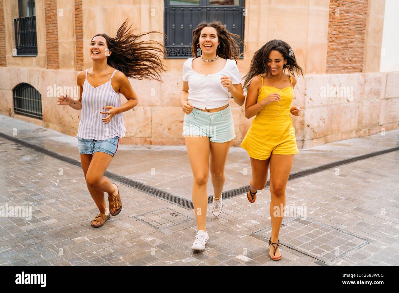 Drei glückliche Freunde laufen in der Stadt Stockfoto
