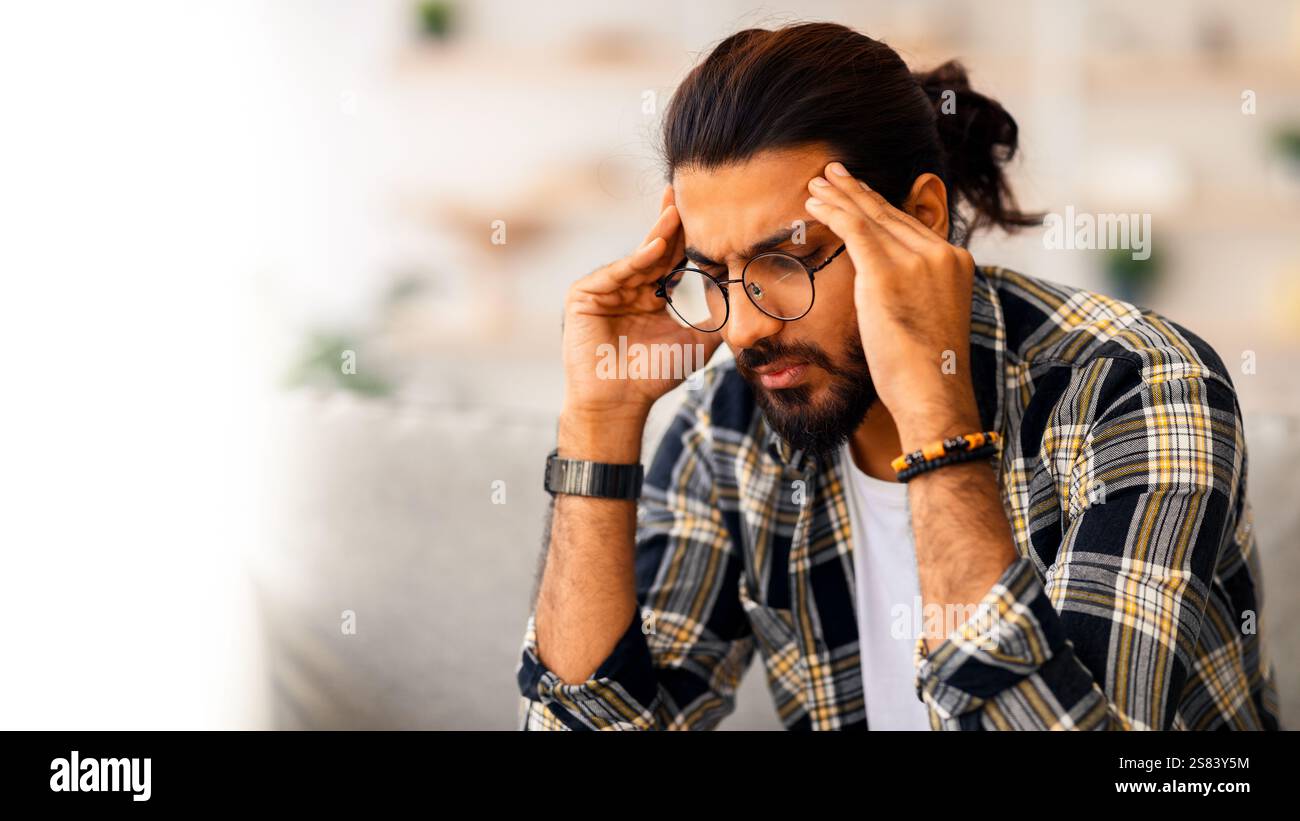 Nahaufnahme eines traurigen arabischen Mannes, der seinen Kopf berührt Stockfoto