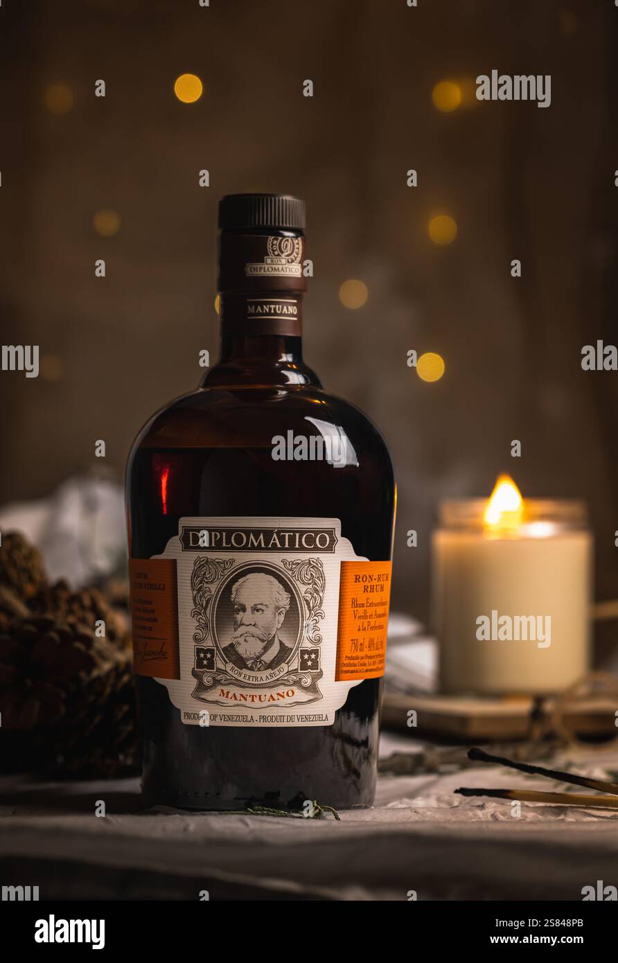 Eine Flasche Diplomático Mantuano Rum in gemütlichem Ambiente mit warmem Kerzenlicht und festlicher Einrichtung, perfekt für einen raffinierten und entspannenden Abend. Stockfoto