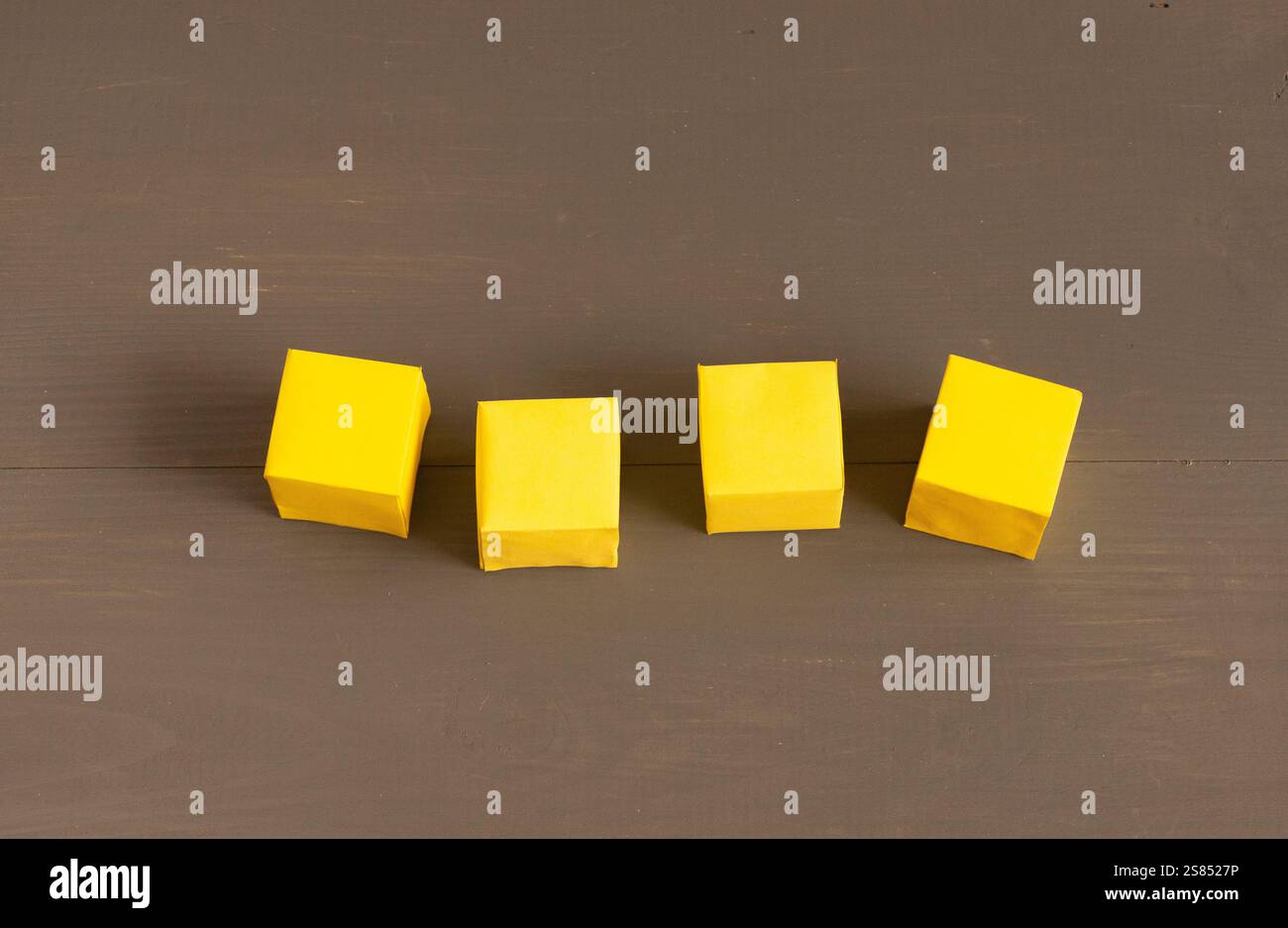 Gelbe leere Papierwürfel auf dunklem Hintergrund Stockfoto