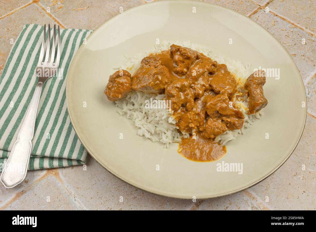 Lammcurry und thailändischer Reis auf einem Teller Stockfoto
