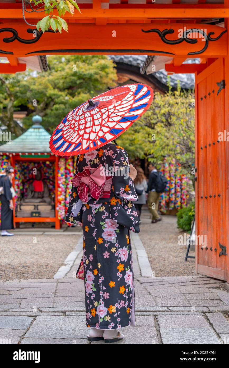 Blick auf die Dame in Kimono mit farbenfrohem Sonnenschirm in der Straße in der Nähe des Torii Tores in Gion, KKyoto Geisha District, Kyoto, Honshu, Japan Stockfoto Blick auf die Dame in Kimono mit farbenfrohem Sonnenschirm in der Straße in der Nähe des Torii Tores in Gion, KKyoto Geisha District, Kyoto, Honshu, Japan Stockfoto