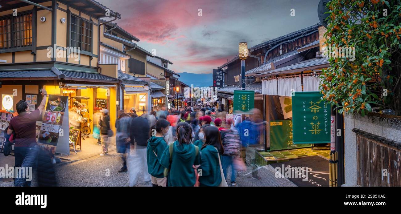 Blick auf die belebte Straße und traditionelle Holzhäuser und Geschäfte in Gion, Kyoto Geisha District, Kyoto, Honshu, Japan Stockfoto