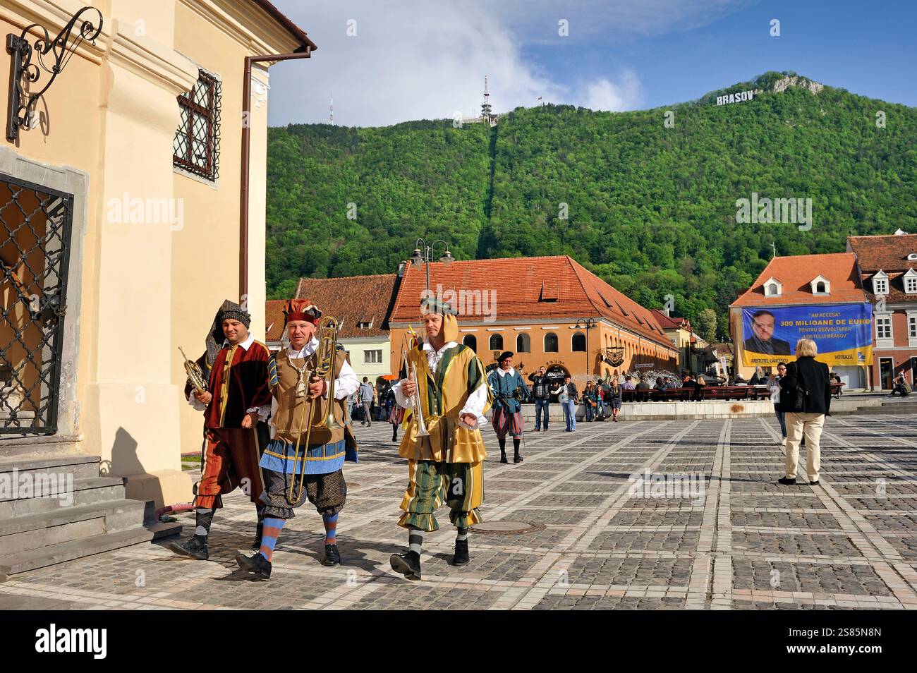 Musiker in mittelalterlichen Kostümen spielen jede Stunde eine Melodie vom Stadthaus, dem Platz des Rates (piata Sfatului), Brasov, Siebenbürgen, Rumänien Stockfoto