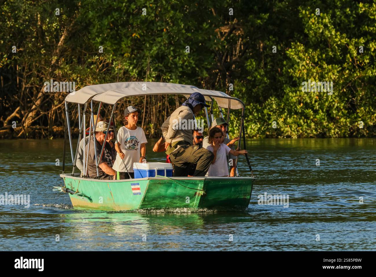 Touristen auf Bootsfahrt durch die Mangroven gesäumte Flussmündung des Flusses Nosara und das biologische Reservat bei Sonnenuntergang, Boca Nosara, Nosara, Guanacaste, Costa Rica Stockfoto