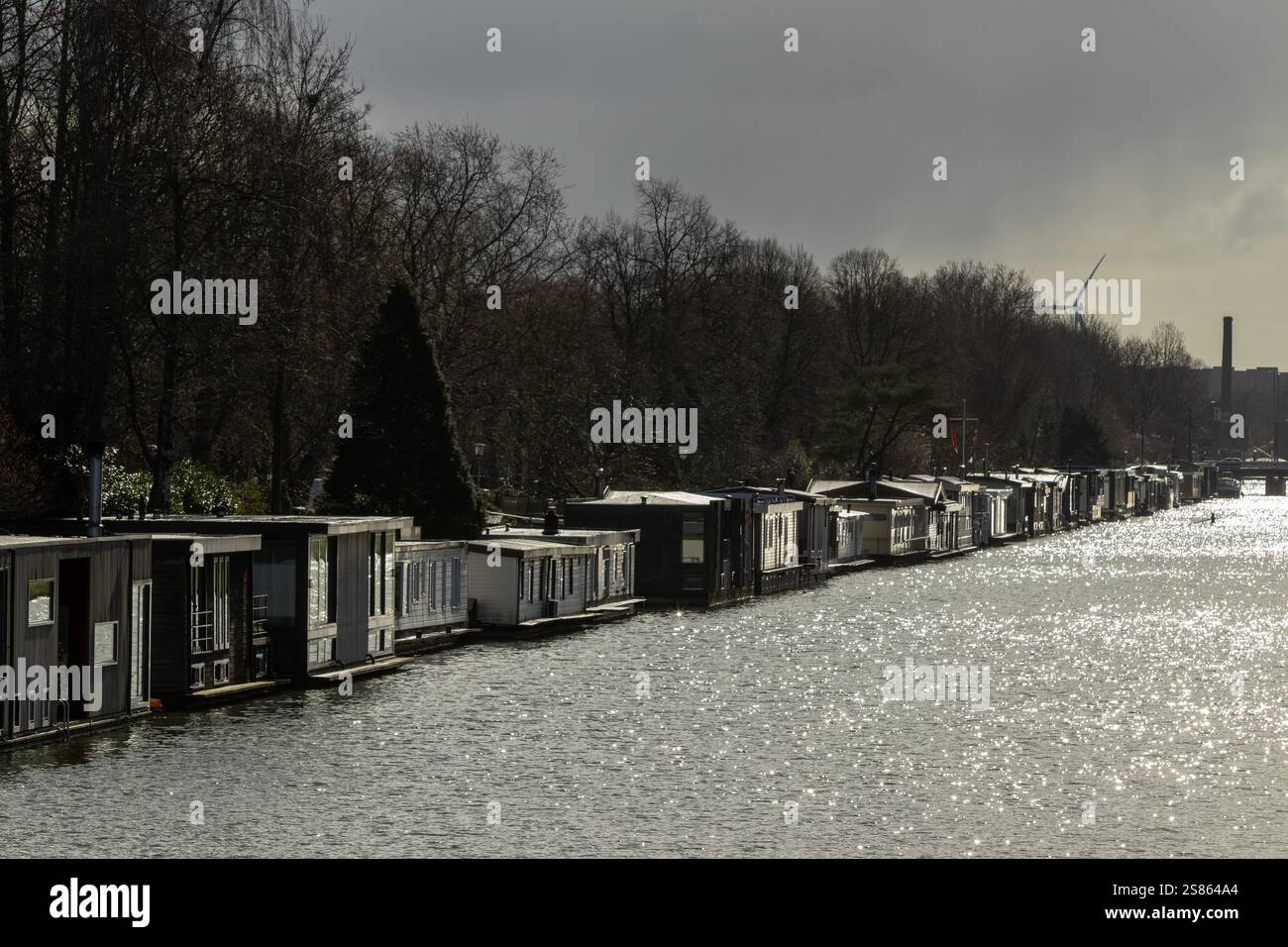 Hausboote in Utrecht an einem grauen Tag mit niedriger Sonne, die im Wasser reflektiert. Stockfoto