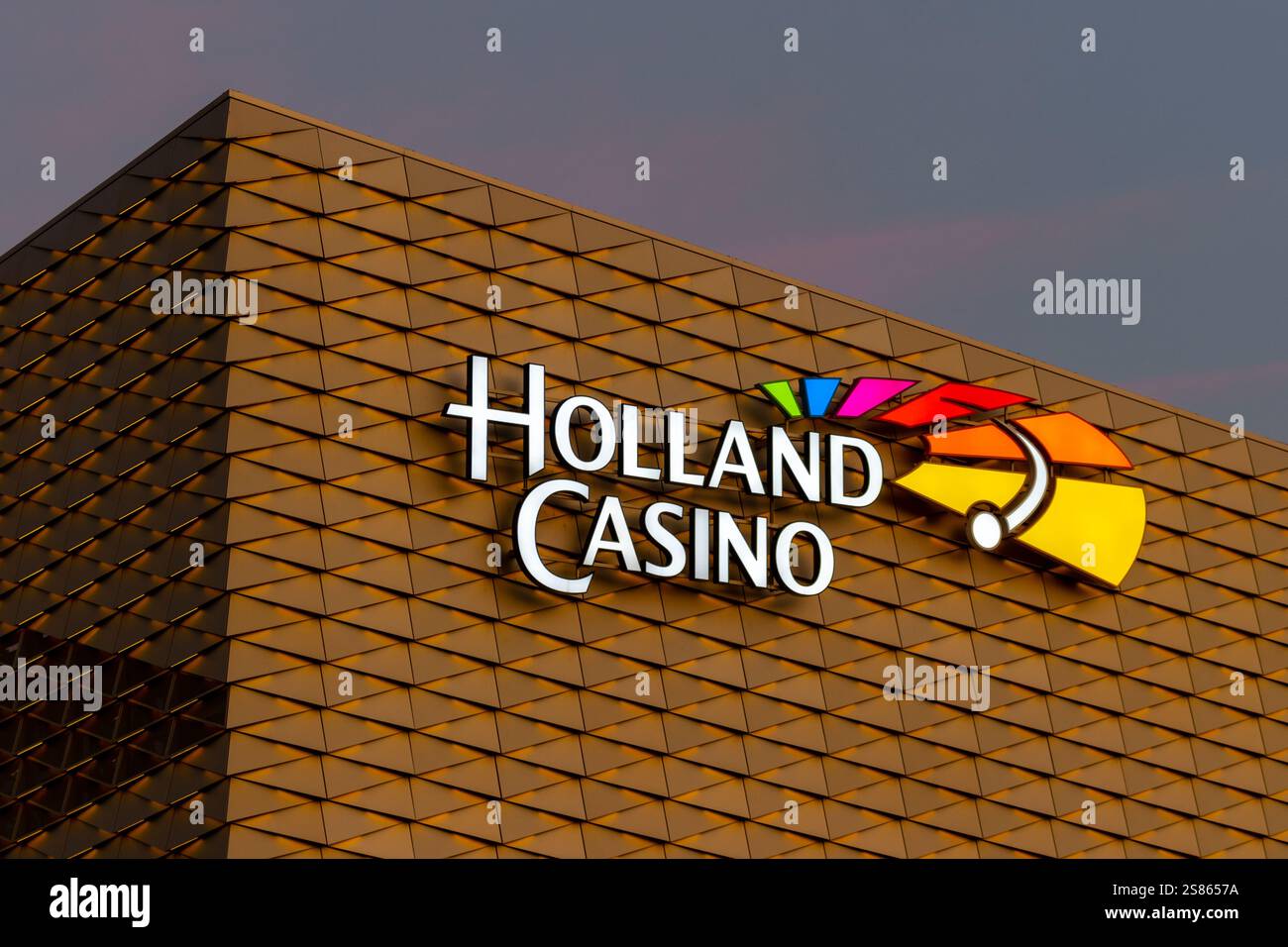 Das beleuchtete Holland Casino-Logo auf dem beleuchteten Gebäude. Stockfoto