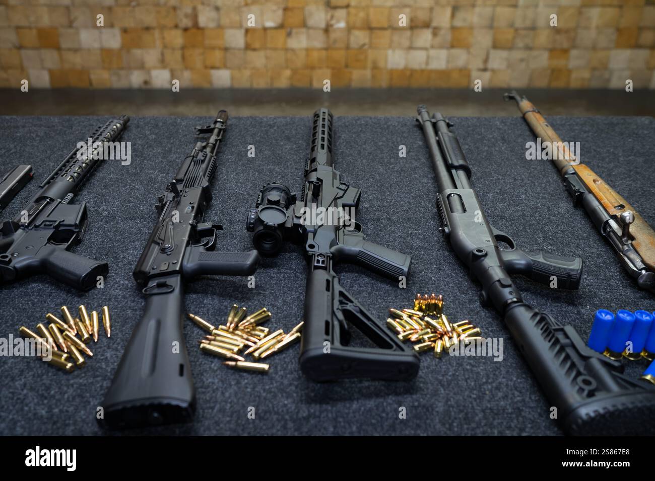 Verschiedene Schusswaffen auf einem Tisch in einem Schießstand, Nahaufnahme. Stockfoto