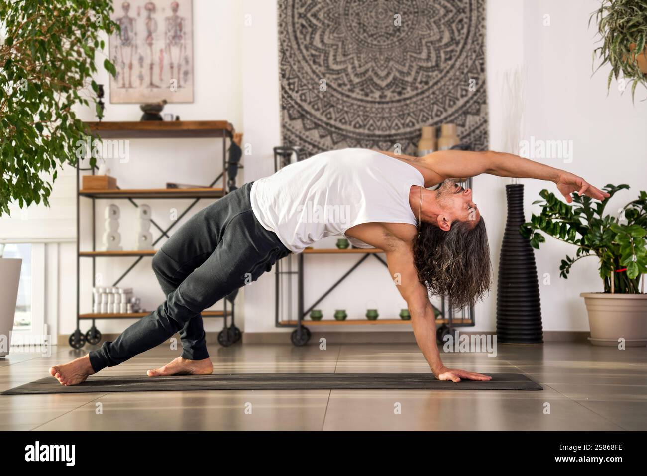 Yogalehrer hält eine wilde Sache oder Camatkarasana Yoga-Pose in einem hellen Yoga-Studio Stockfoto
