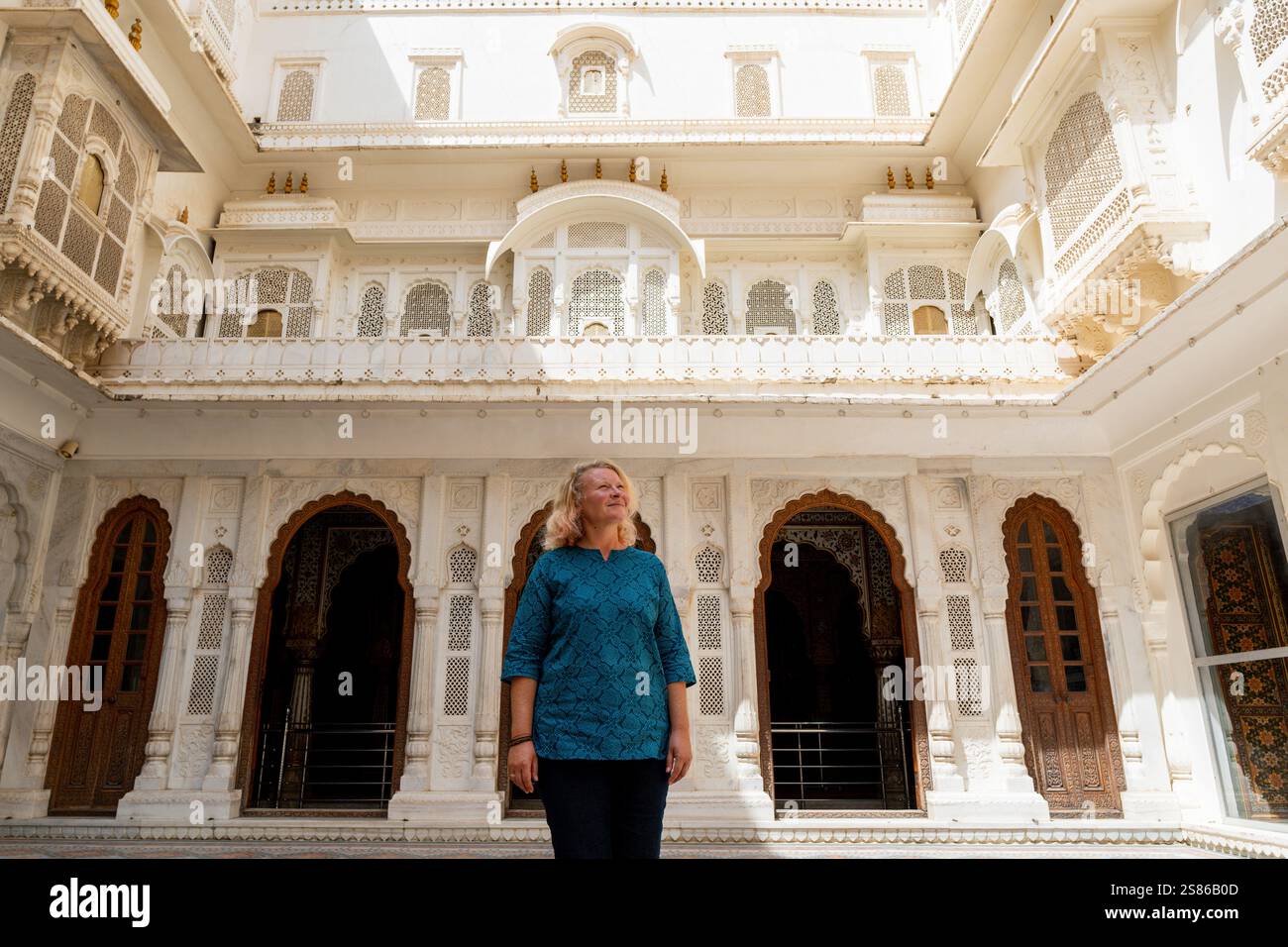 Die junge blonde Frau erkundet die architektonische Schönheit des Bikaner Stadtfestes in Rajasthan, Indien. Stockfoto