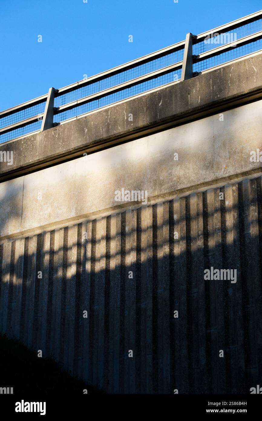 Detail einer Beton- und Stahlbrücke über eine Autobahn mit blauem Himmel. Stockfoto