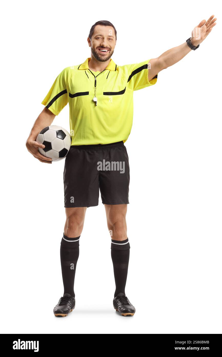 Fußballschiedsrichter hält einen Ball und zeigt mit der Hand isoliert auf weißem Hintergrund Stockfoto