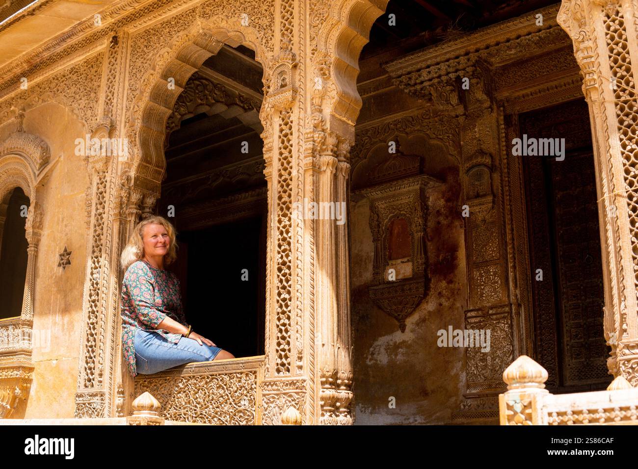 Junge blonde Europäerin, die in Rajasthan reist und die Altstadt von Jaisalmer, Indien, erkundet. Stockfoto