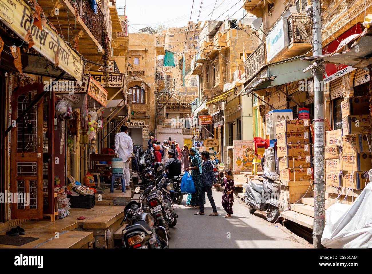 JAISALMER, INDIEN - 31. MÄRZ 2024: Belebte Straße mit Verkaufsständen und Indianern, die einkaufen Stockfoto
