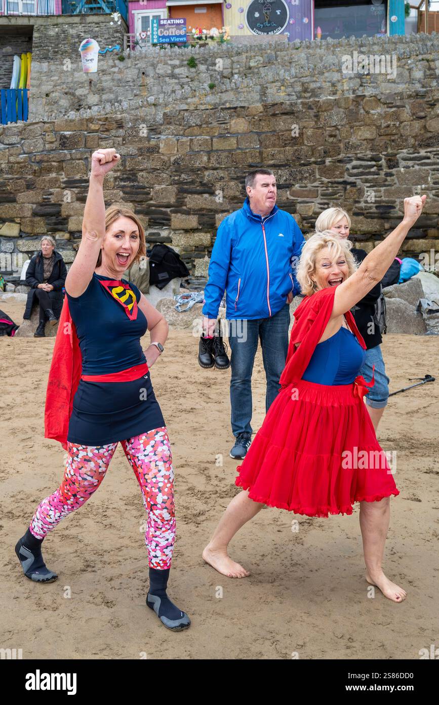 Die Teilnehmer treffen sich am Strand von Towan und bereiten sich auf die jährliche Veranstaltung „Superhero in the Cold“ vor, um Spenden für die britische Krebsforschung zu sammeln. Stockfoto
