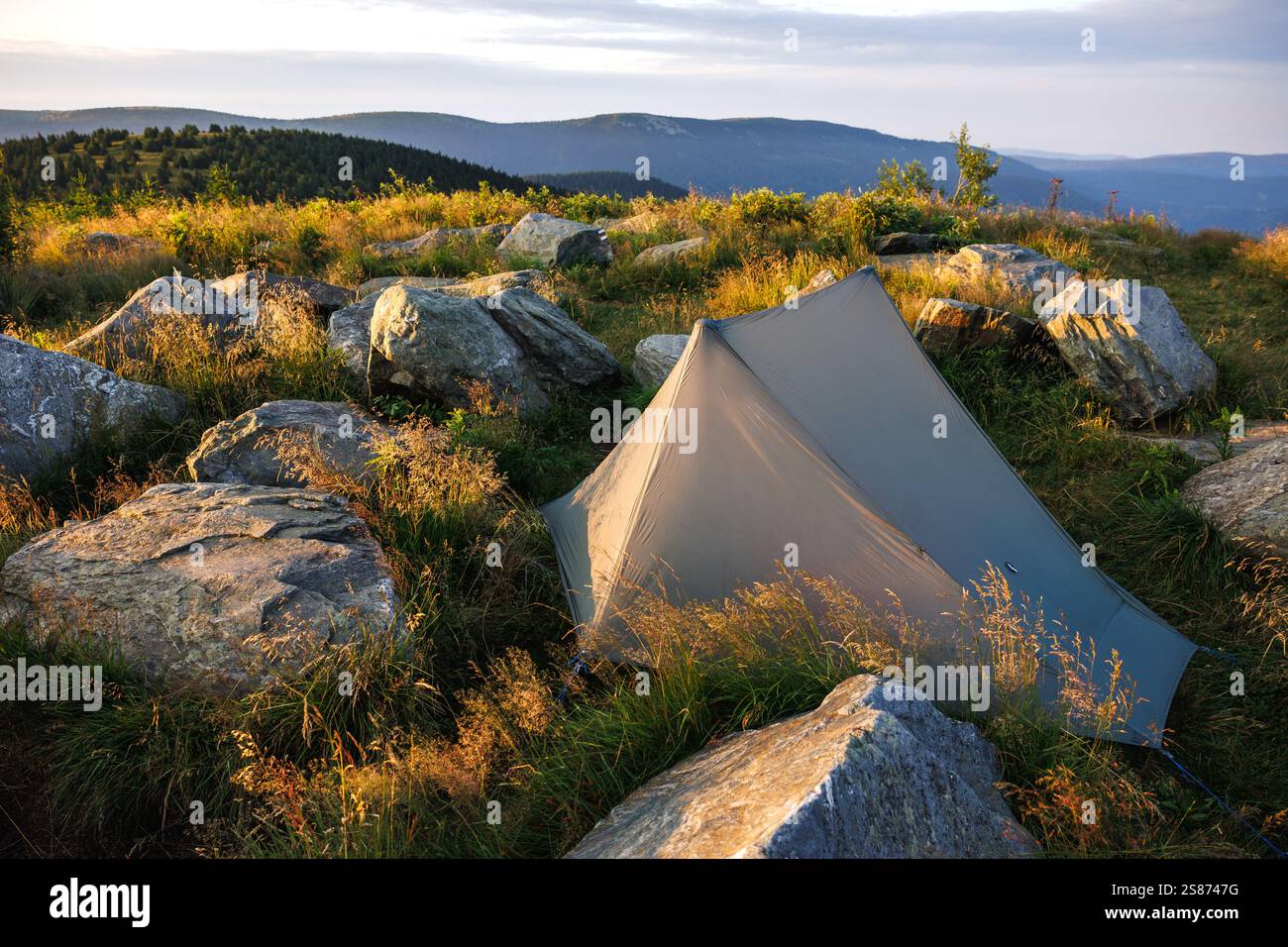 Wildes Camping mit ultraleichtem Zelt auf dem Berggipfel während der Wanderung. Abenteuer in der Natur Stockfoto