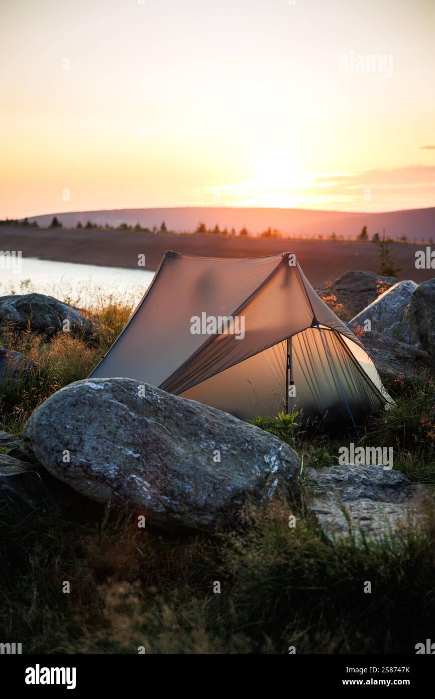 Camping in Bergen am See bei Sonnenaufgang. Ultraleichtes Zelt für Alleinwanderungen. Outdoor-Abenteuer Stockfoto
