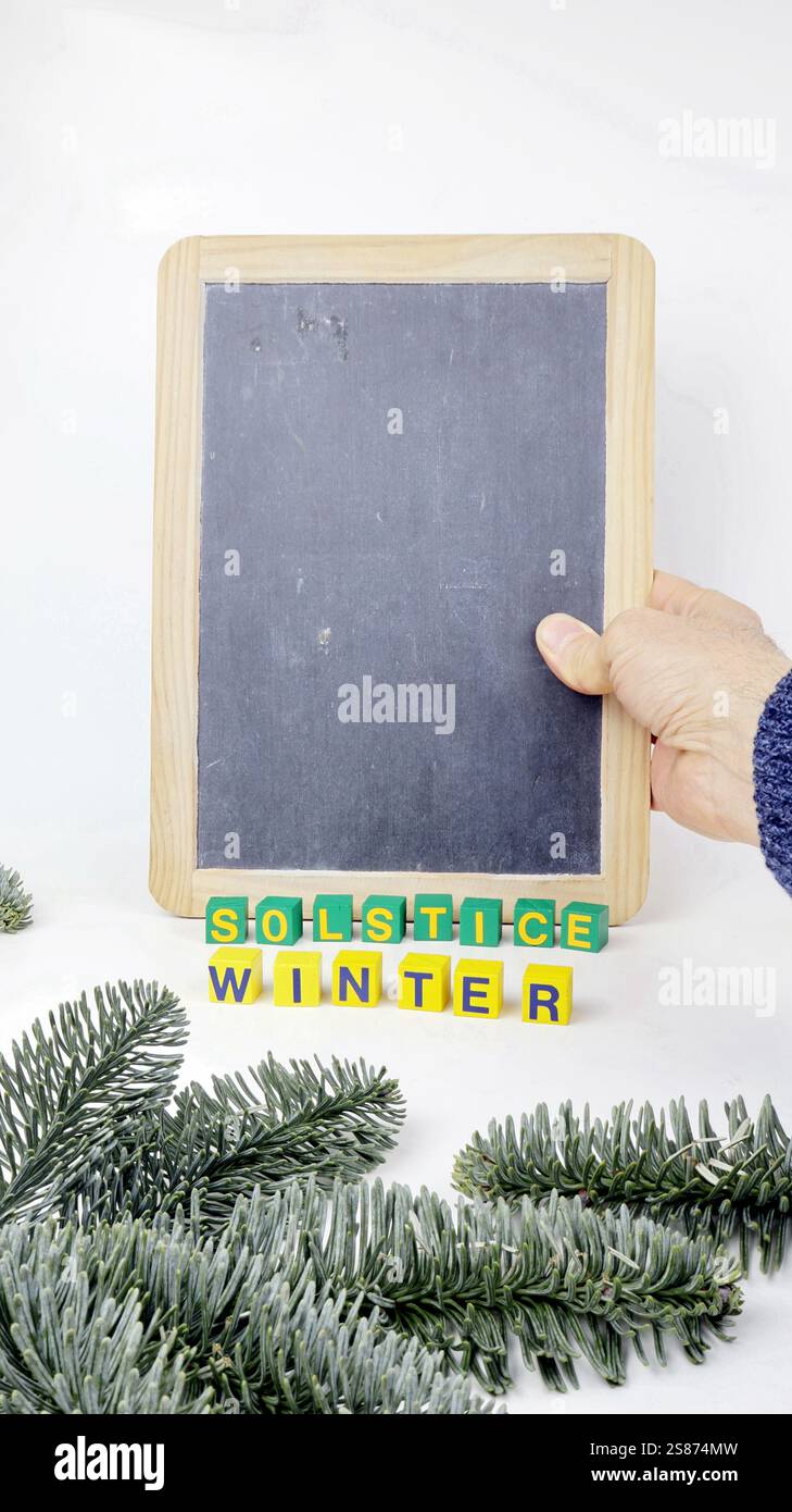 Winter Solstice Party mit einem Wort Kopierraum auf Holzwürfel geschrieben und Vintage Schule Kreidetafel mit weißem Hintergrund. Stockfoto