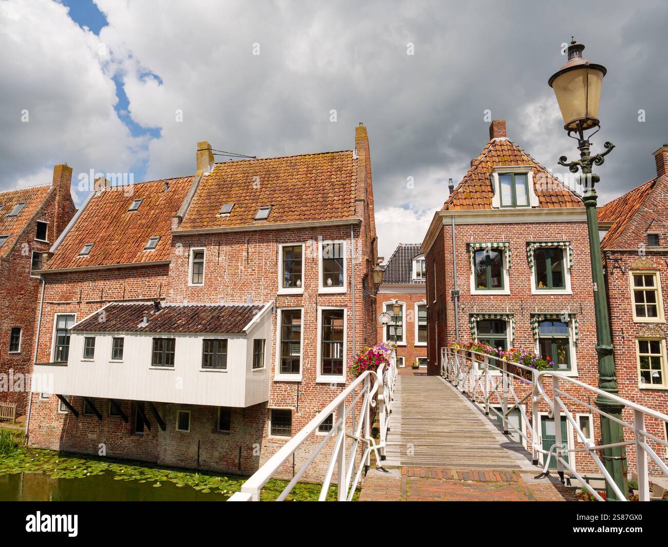 Kanalhäuser mit hängenden Küchen über dem Damsterdiep-Kanal in der historischen Stadt Appingedam, Eemsdelta, Groningen, Niederlande Stockfoto